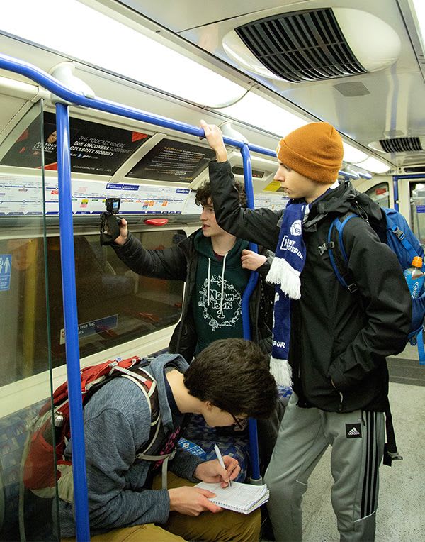 Eitan, Micha and Gabriel study their progress on the tube to Heathrow