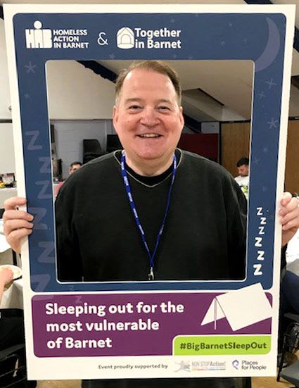 HAB Chair John Bier at the Big Barnet Sleep Out holding a picture frame which says "Sleeping out for the most vulnerable of Barnet" 
